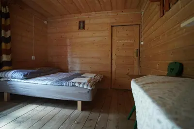 a bedroom with two beds in a wooden cabin at Dom na końcu świata in Ochotnica Górna
