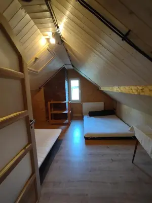 an attic room with two beds and a window at Dom na końcu świata in Ochotnica Górna