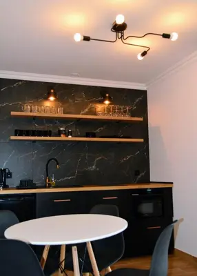a kitchen with a white table and some chairs at Leśna Muzyka Apartment Limanowa in Limanowa