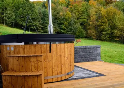 a wooden stage with a black top on a wooden deck at Leśna Muzyka Apartment Limanowa in Limanowa