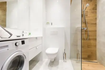 a white bathroom with a toilet and a shower at Zabłocie Apartament Oasis in Kraków
