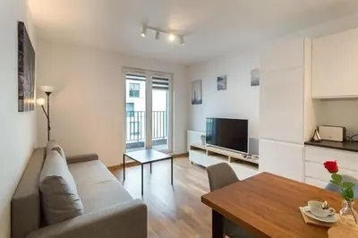 a living room with a couch and a table at Zabłocie Apartament Oasis in Kraków