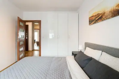 a bedroom with a bed and a painting on the wall at Zabłocie Apartament Oasis in Kraków
