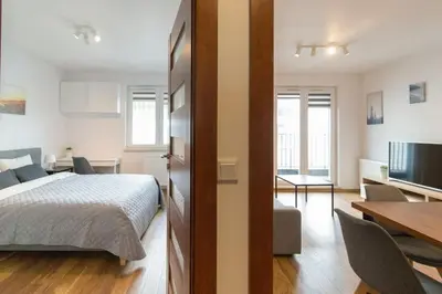 a bedroom with a bed and a dining room at Zabłocie Apartament Oasis in Kraków