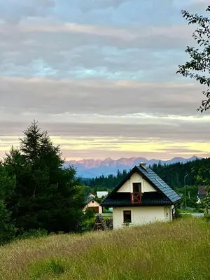 a rainbow in the sky above a house at Domek Babiogórski z JACUZZI in Zubrzyca Górna