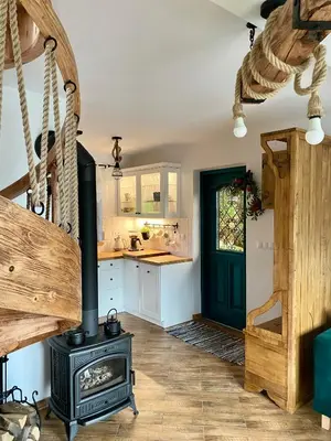 a kitchen with a wood stove in a room at Domek Babiogórski z JACUZZI in Zubrzyca Górna