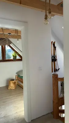 a bedroom with a bed and a stool next to it at Domek Babiogórski z JACUZZI in Zubrzyca Górna
