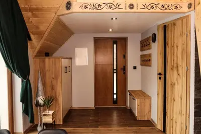 a hallway with a wooden door and wooden floors at Domek Parzenica Nowy Targ in Nowy Targ