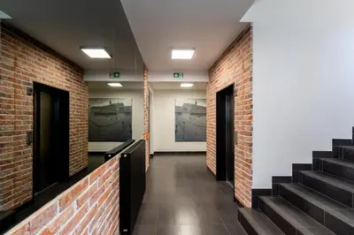 a hallway with brick walls and stairs in a building at Cracow Novum Apartment #58 by BookingHost in Kraków