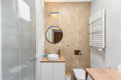 a bathroom with a sink and a mirror at Cracow Novum Apartment #58 by BookingHost in Kraków