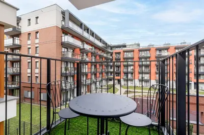 a balcony with a table and chairs on a building at Cracow Novum Apartment #58 by BookingHost in Kraków