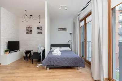 a bedroom with a bed and a tv in it at Cracow Novum Apartment #58 by BookingHost in Kraków