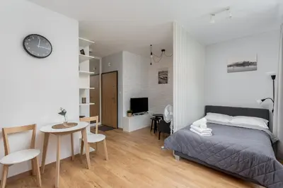 a bedroom with a bed and a table and a desk at Cracow Novum Apartment #58 by BookingHost in Kraków