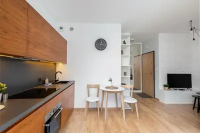 a kitchen with a table and chairs in a room at Cracow Novum Apartment #58 by BookingHost in Kraków