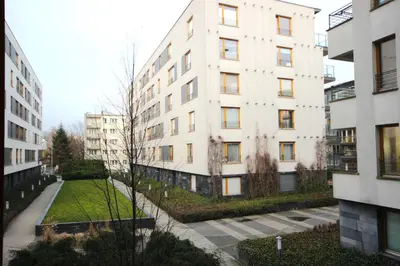 a tall white building with a grass yard in front of it at VIVA LILA Apartment, FREE PARKING, close to Vistula River - by Homelike Krakow in Kraków