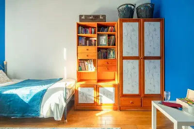 a bedroom with a book shelf next to a bed at Botaniczny Pokój in Kraków