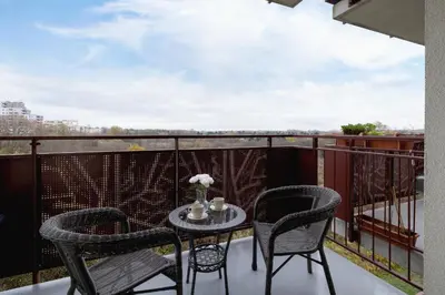 a table and chairs on a balcony with a view at Near EXPO Cracow Elegant Apartment by Noclegi Renters in Kraków