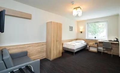 a hospital room with a bed and a desk at Automobil Hotel in Kraków