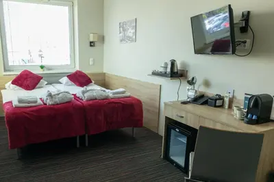 a hotel room with a bed and a television at Automobil Hotel in Kraków