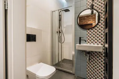 a bathroom with a shower and a toilet and a sink at Skawinska Suites by Fragola Apartments in Kraków