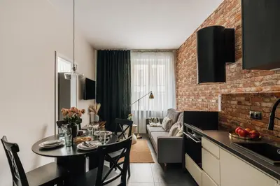 a vase with pink flowers sitting on a table at Skawinska Suites by Fragola Apartments in Kraków