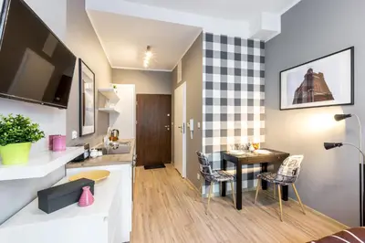 a kitchen and living room with a table and chairs at Wonderful Apartments in the Center of Krakow in Kraków