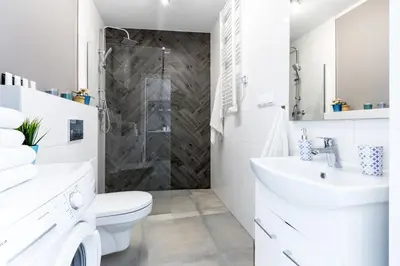 a white bathroom with a shower and a toilet at Wonderful Apartments in the Center of Krakow in Kraków