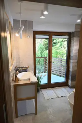 a bathroom with a sink and a tub and a window at Chatka Beatki in Stryszawa