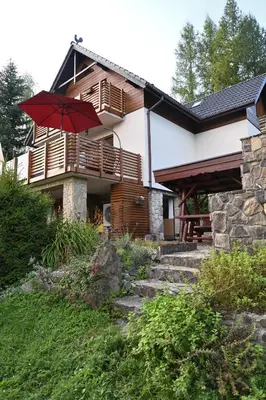a house with a red umbrella in front of it at Chatka Beatki in Stryszawa