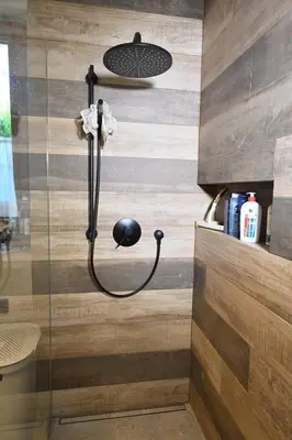 a shower with a shower head on a wooden wall at Chatka Beatki in Stryszawa