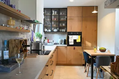 a kitchen with wooden cabinets and a table with a wine glass at Chatka Beatki in Stryszawa