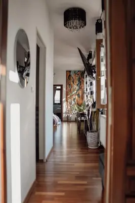 a hallway of a home with wooden floors and a chandelier at Apartament w centrum Brzeska 1 in Brzesko