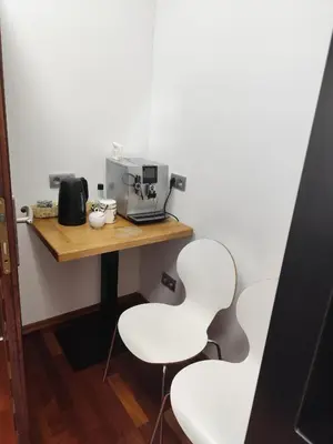 a table with two white chairs and a coffee maker at Apartament w centrum Brzeska 1 in Brzesko