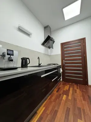 a kitchen with a black counter and a wooden floor at Apartament w centrum Brzeska 1 in Brzesko