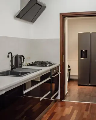 a kitchen with a stove and a stainless steel refrigerator at Apartament w centrum Brzeska 1 in Brzesko