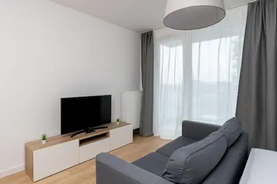 a living room with a couch and a flat screen tv at Tauron Modern Studio by BookingHost in Kraków