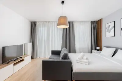 a bedroom with a bed and a couch and a tv at Tauron Modern Studio by BookingHost in Kraków