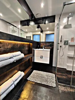 a bathroom with a shower and a sink with towels at Szlak Apartment Old Town in Kraków