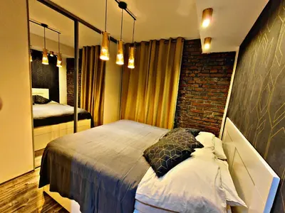 a bedroom with a bed and a brick wall at Szlak Apartment Old Town in Kraków