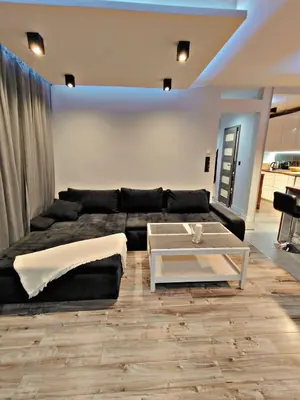 a living room with a black couch and a table at Szlak Apartment Old Town in Kraków