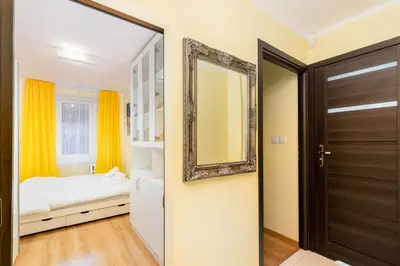 a bedroom with a mirror and a bed at Kalinowe Green Apartment by BookingHost in Kraków