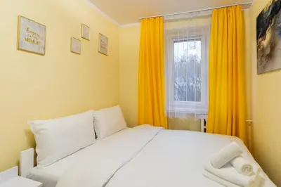 a bedroom with a white bed and a window at Kalinowe Green Apartment by BookingHost in Kraków