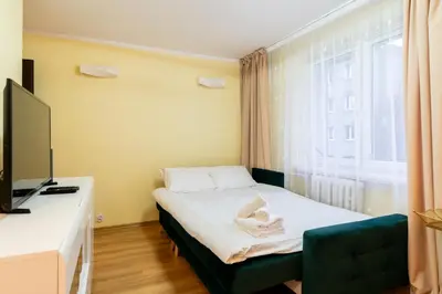 a bedroom with a bed and a desk and a window at Kalinowe Green Apartment by BookingHost in Kraków