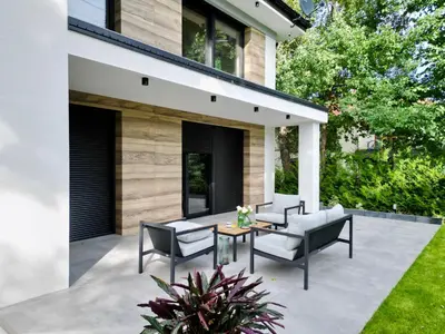 a patio with chairs and a table in front of a house at BM Apartments - parter domu z tarasem in Kraków