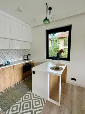 a kitchen with a white counter and a window at BM Apartments - parter domu z tarasem in Kraków