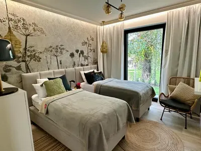 a bedroom with two beds and a couch and a window at BM Apartments - parter domu z tarasem in Kraków