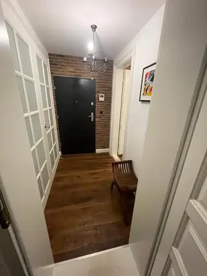 a hallway with a black door and a chair at Royal Oak - 3BD 2BA apartment with parking and river view in Kraków