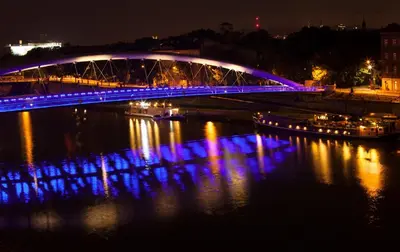 a blue bridge over a river at night at Royal Oak - 3BD 2BA apartment with parking and river view in Kraków