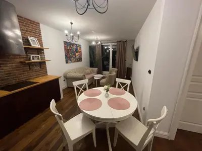 a dining room and living room with a table and chairs at Royal Oak - 3BD 2BA apartment with parking and river view in Kraków