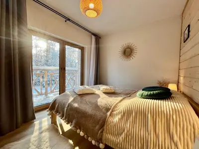a bedroom with a bed with a large window at Villa Corvo Bianco in Sidzina